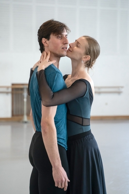 Ein Tanzpaar steht eng aneinander in einem hellen Proberaum