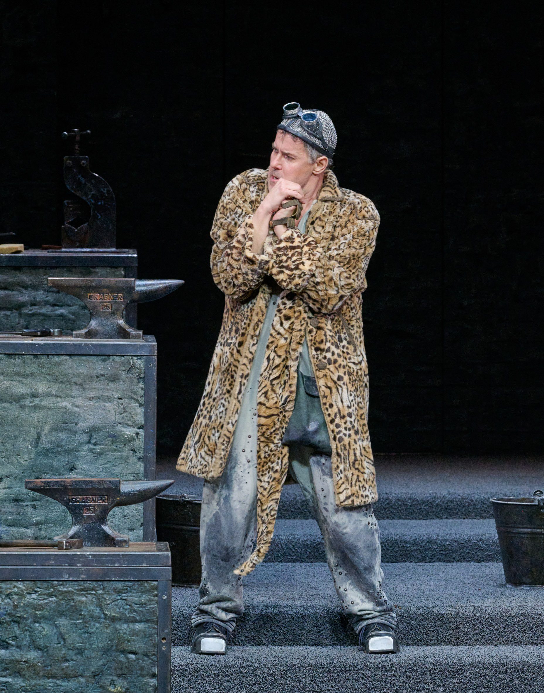 Ein Mann im braunen Mantel blickt nachdenklich zur Seite.