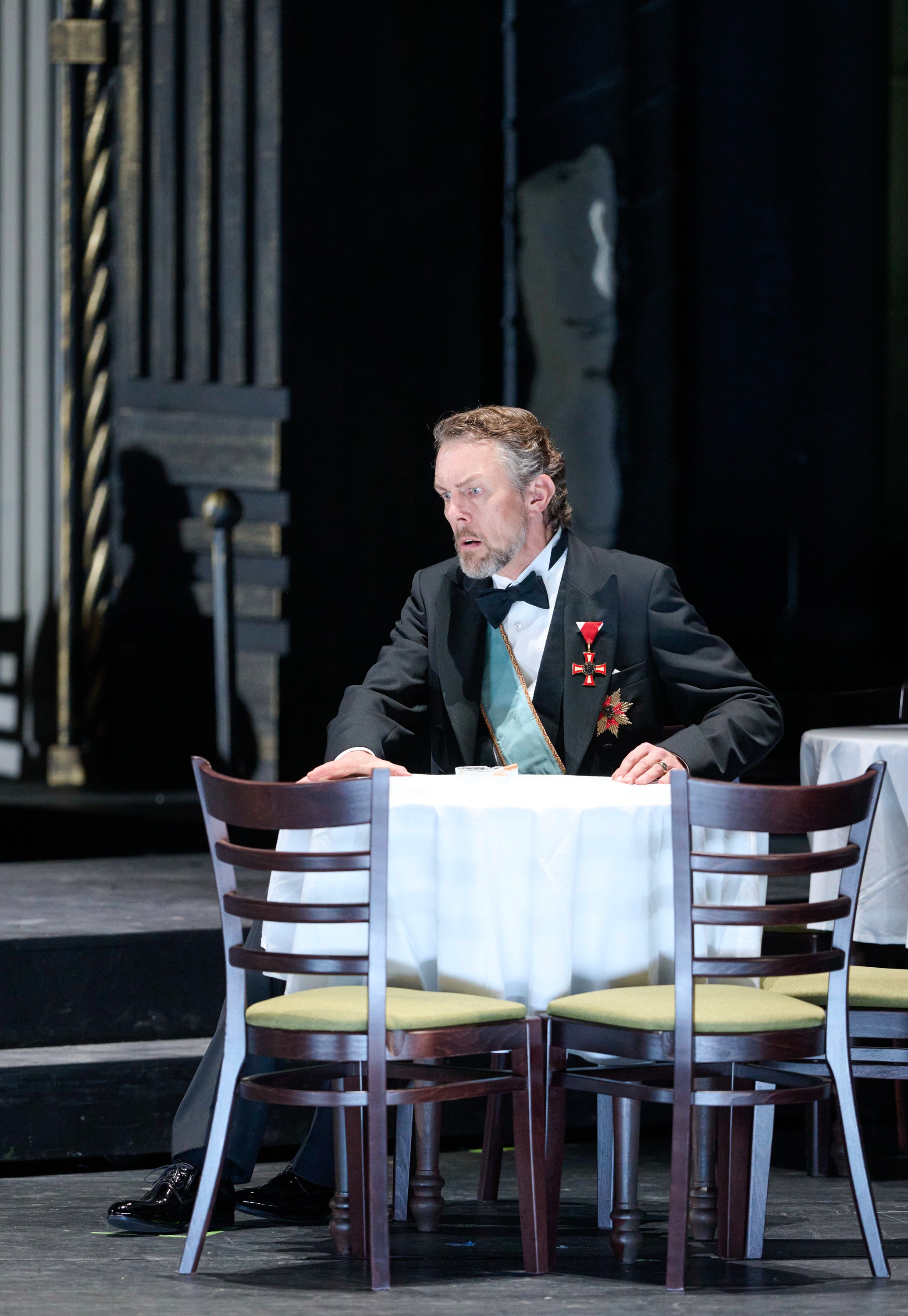 Ein Mann in einem Smoking mit Verzierungen daran und einer Schärpe.